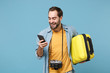 Cheerful traveler tourist man in casual clothes with photo camera isolated on blue background. Male passenger traveling abroad on weekends. Air flight journey concept Hold suitcase using mobile phone.