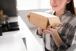 © LIGHTFIELD STUDIOS - cropped view of smiling woman holding paper bag with popcorn near microwave in kitchen