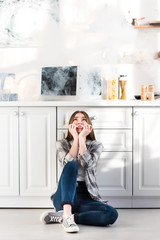 Wall Mural - scared and attractive woman looking at broken microwave in kitchen