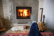 © Ivan Kmit - Hygge concept with man legs in wool socks near burning fireplace