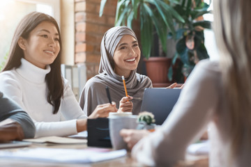 Canvas Print - Asian girl and lady in hijab smiling during business meeting