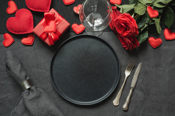 Wall Mural - Valentine's day or birthday dinner. Romantic table setting with red rose on black linen tablecloth.