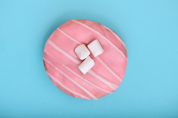 Wall Mural - pink donut on a blue background, the concept of minimalism, a game of color. Blue background, copy space, shot from above. Game of color. fashion