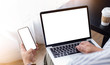 © panitan - mockup image blank screen computer,cell phone with white background for advertising text,hand man using laptop texting mobile contact business search information on desk in cafe.marketing,design