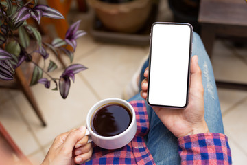 Mockup image blank white screen cell phone.woman hand holding texting using mobile on desk at coffee shop.background empty space for advertise text.people contact marketing business,technology 