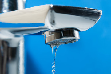 Modern tap and water drop on blue background