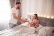 © Jelena - Man surprising girl with a breakfast in bed.
