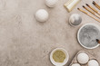 © LIGHTFIELD STUDIOS - top view of chicken eggs, silver and golden glitter with paintbrushes on grey concrete surface
