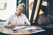 © BullRun - Concentrated woman writing in notebook in cafe