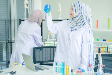 Young female scientist Female Scientists in protective glasses and gloves testing tube chemical ingredient,test samples of antibiotics and future food used in medical development for people