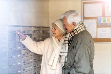 Poster - Senior couple unlocking apartment mailbox