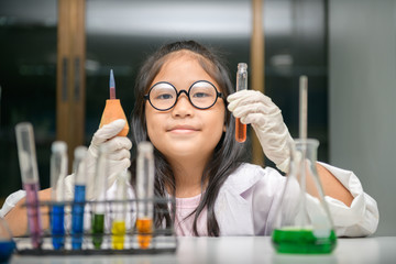 Wall Mural - little scientist use dropper to making experiment in chemical laboratory,