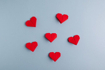 Wall Mural - Love day. Handmade DIY red origami hearts on a blue background. Top view.