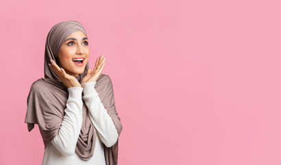 Wall Mural - Portrait of amazed muslim woman in hijab over pink background