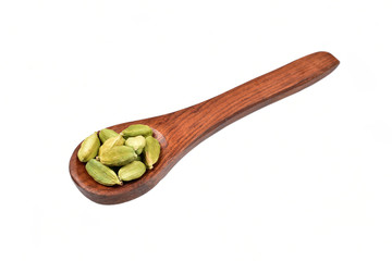 Sticker - cardamom in wooden spoon over white background