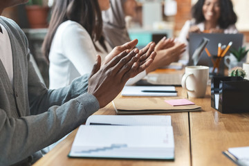 Canvas Print - Close up of international team of employees clapping hands