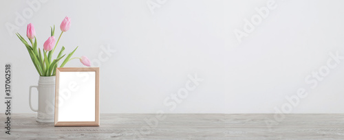 Cuadros en Lienzo wooden frame and pink tulips in white ceramic vase on background white wall