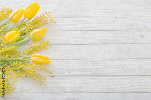 Fotografía tulips and mimosa on white wooden background