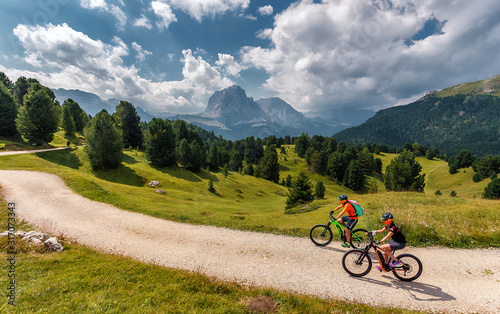 Wonderful Nature Landscape. Mountain biking couple with bikes on track. Val Gardena. Dolomites Alps. Italy. Travel Lifestyle wanderlust adventure concept. Outdoor wilderness vacations.