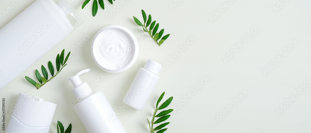 Natural organic SPA cosmetic products set with green leaves. Top view herbal skincare beauty products on green background. Banner mockup for eco shop or beauty salon. Flat lay minimalist style - obrazy, fototapety, plakaty 