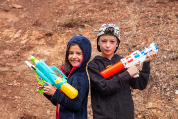 Wall Mural - Cute girl and boy with water guns