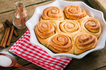 Wall Mural - Sweet cinnamon rolls on a wooden table, homemade cakes