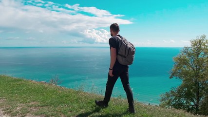 Fototapete - adventure, travel, tourism, hike and people concept - hiking man with backpack looking at sea or ocean in summer