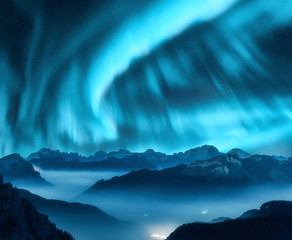 Wall Mural - aurora borealis above the mountains in fog at night. northern lights. sky with stars with polar ligh