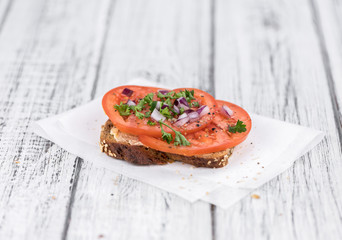 Canvas Print - Some Tomato Sandwich on a vintage wooden table (selective focus; close-up shot)