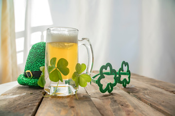 St. Patricks Day green shamrocks with a full cold frosty glass of beer   background