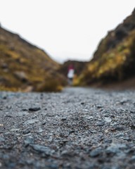 Poster - Vertical shot of wet ground with a blurred person in the background