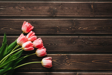 Wall Mural - bouquet of pink Tulip flowers on a brown wooden table.