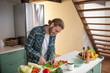 © zinkevych - Smiling man cutting cherry tomatoes for a salad