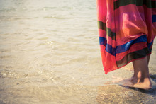 Close-up Of A Woman Standing In Shallow Water At The Beach.