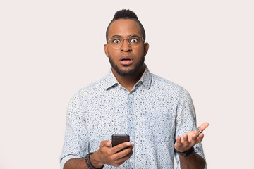 Wall Mural - Surprised black man confused by unexpected message on smartphone