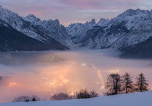 A Dense Fog Dominates The Village Of Dobbiaco That Lights Up After Sunset, In The Background The Peaks Of Dobbiaco, Piz Popena And Monte Cristallo, Pusteria Valley