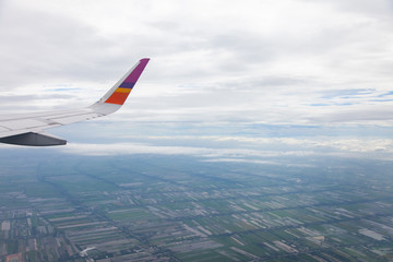 Aircraft Wing on blue sky and white clouds background.