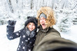 © satura_ - Season, love, technology and leisure concept - happy couple taking selfie by smartphone over winter background