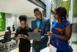 © JonoErasmus - Three black african colleagues walking through coworking workspace strategizing on their way to boardroom business meeting