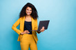 © deagreez - Photo of pretty assistant dark skin wavy lady holding notebook search information internet help boss friendly worker wear specs yellow suit blazer pants isolated blue color background