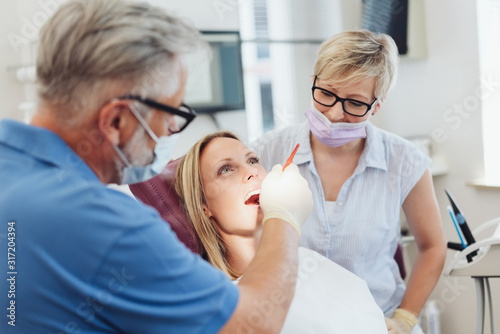 Fotomural Dentist examining the teeth of a female patient
