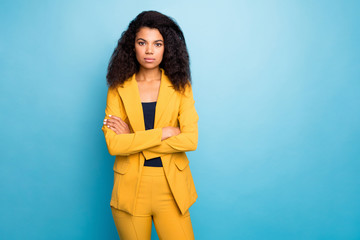 Photo of beautiful dark skin business lady not smiling hands crossed self-confident bossy worker wear stylish yellow office suit trousers jacket isolated blue color background