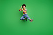 Full length photo of crazy afro american girl hipster jump train kickboxing fight copyspace fall sport kick legs fists wear trendy denim jeans isolated over green color background