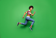 Full Size Profile Side Photo Of Positive Cheerful Afro American Girl Jump Run After Fall Black Friday Bargain Wear Denim Jeans Outfit Isolated Over Green Color Background