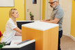 © contrastwerkstatt - Male patient signing in with the receptionist