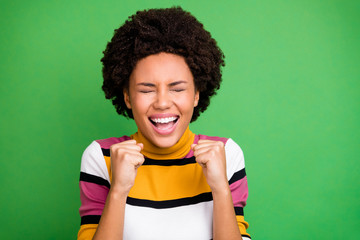 Poster - Close up photo of delighted crazy afro american girl celebrate champion lottery win feel rejoice emotions raise fists scream close eyes wear good look outfit isolated green color background