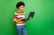 © deagreez - Profile photo of beautiful dark skin wavy lady holding notebook browsing reading news serious professional broker wear casual striped jumper jeans isolated green color background