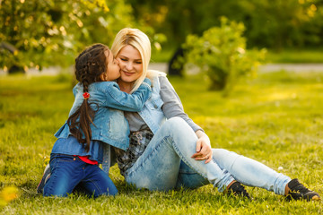 Wall Mural - Happy young woman being kissed by a cute little girl