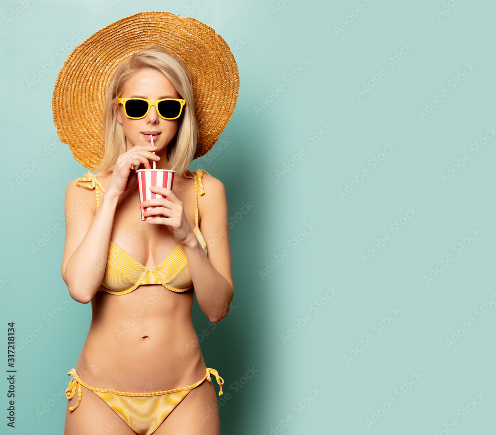 Beautiful blonde woman in bikini with paper cup - obrazy, fototapety, plakaty 