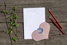 Spring White And Green Blooming Branches And Pink Wooden  Heart  On Paper With Word Plan Over Rustic Wooden Background.